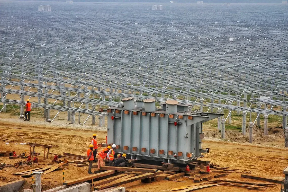 Workers beside solar panels at a construction site